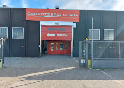 Facciata della Carrozzeria Lainate: insegna arancione, ingresso rosso con scritta Entrata